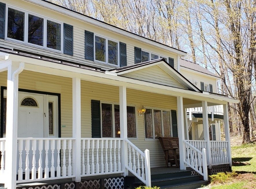 Yellow Victorian farmhouse in Middlebury VT with seamless gutters