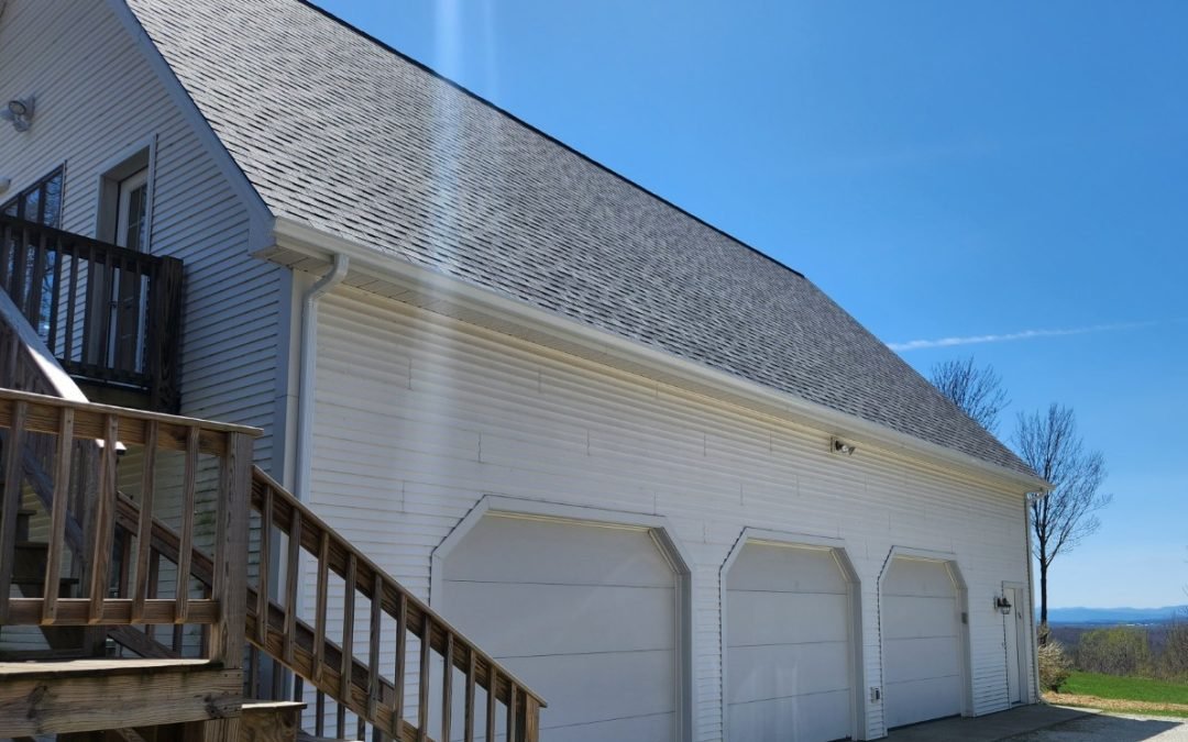 White three-bay garage in Addison County VT with seamless gutters and a mountain view