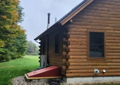 Log cabin in Addison County VT with a seamless gutter along the eave