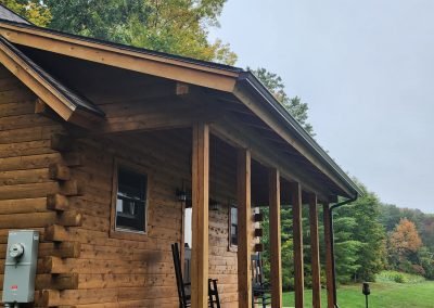Log cabin porch in Vermont with a bronze seamless gutter along the porch roof