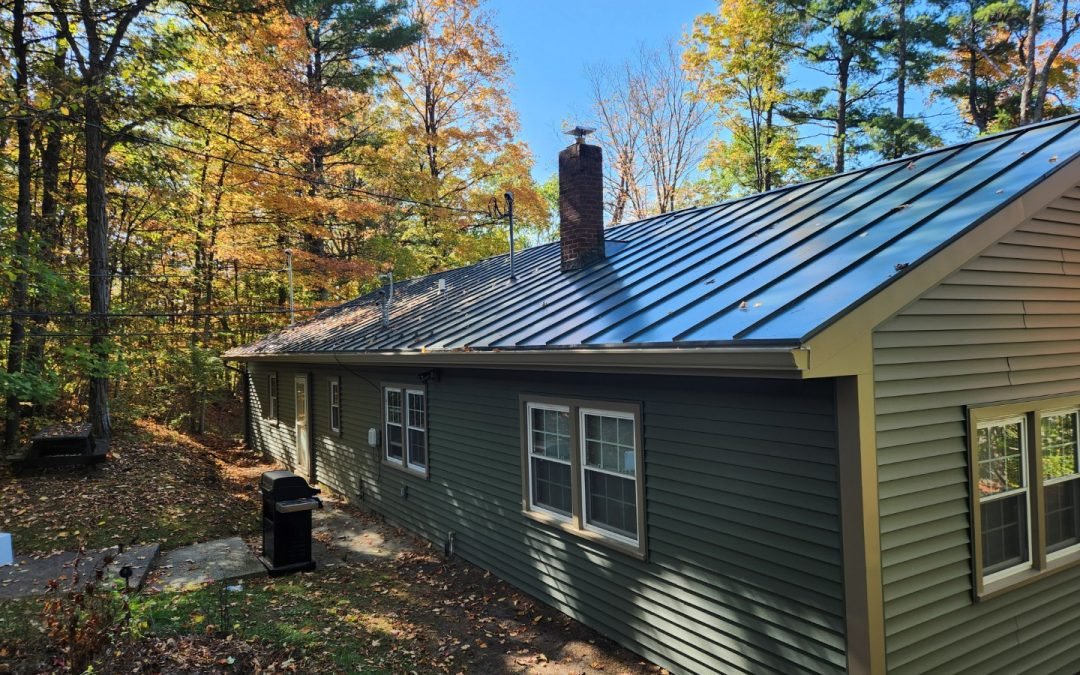Green ranch home near Crown Point NY with a standing seam metal roof and seamless gutters